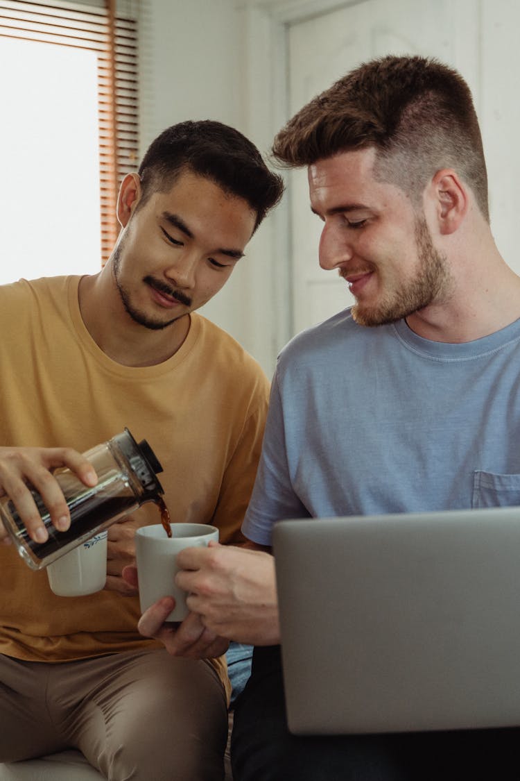 Man Pouring Liquid To Another Person's Mug