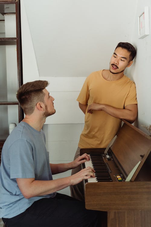 Free One Man Playing the Piano and the Other Looking at Him  Stock Photo