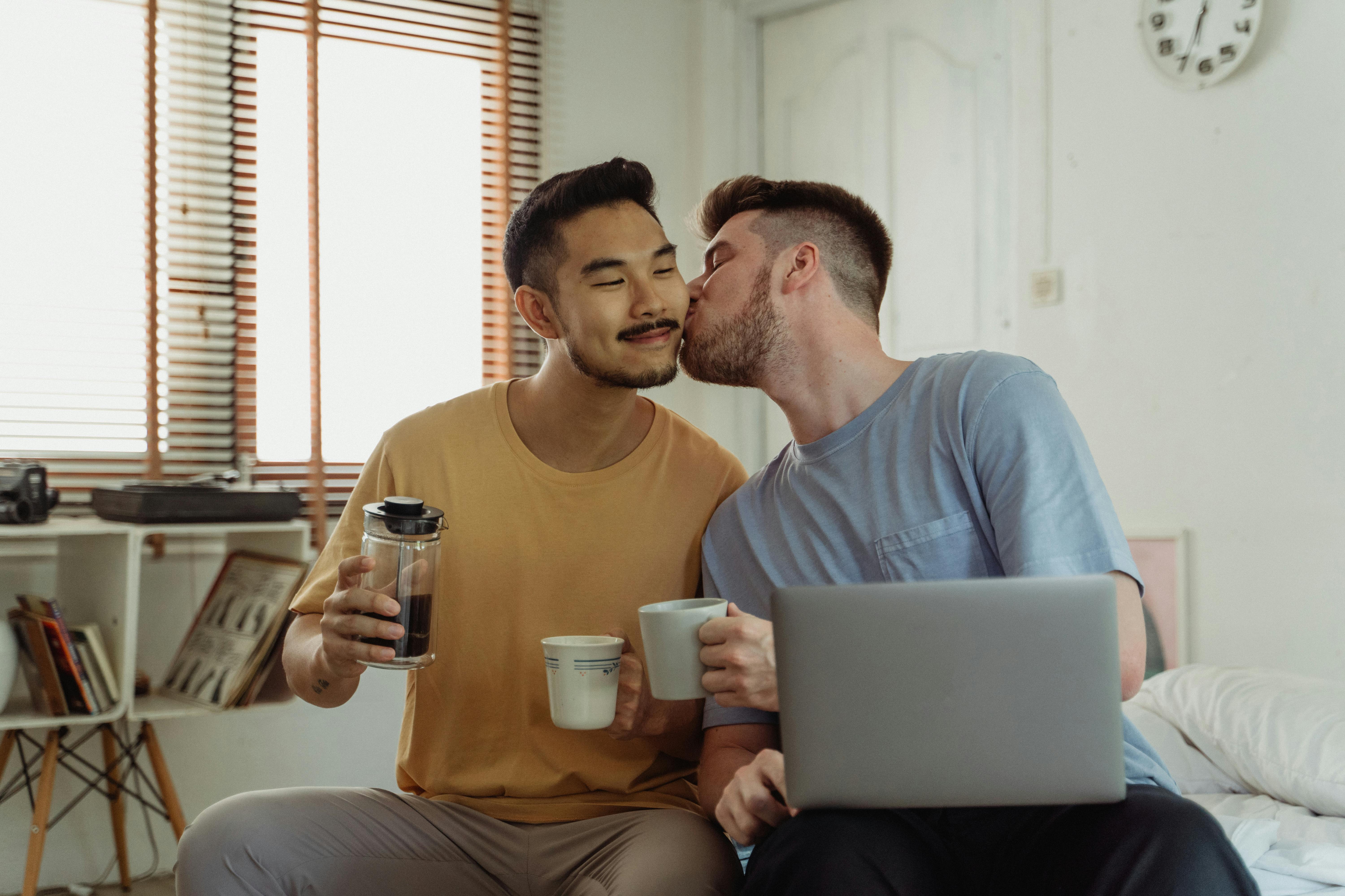 man kissing another man on the cheek