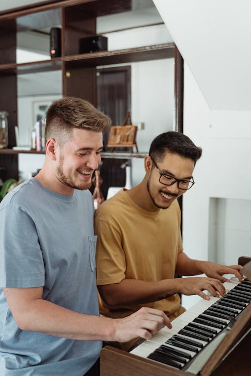 Men Happily Playing Piano Together