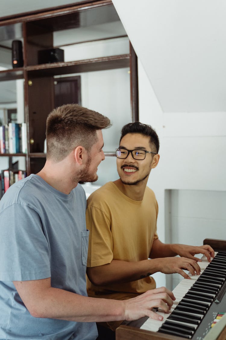 Men Looking At Each Other While Playing Piano