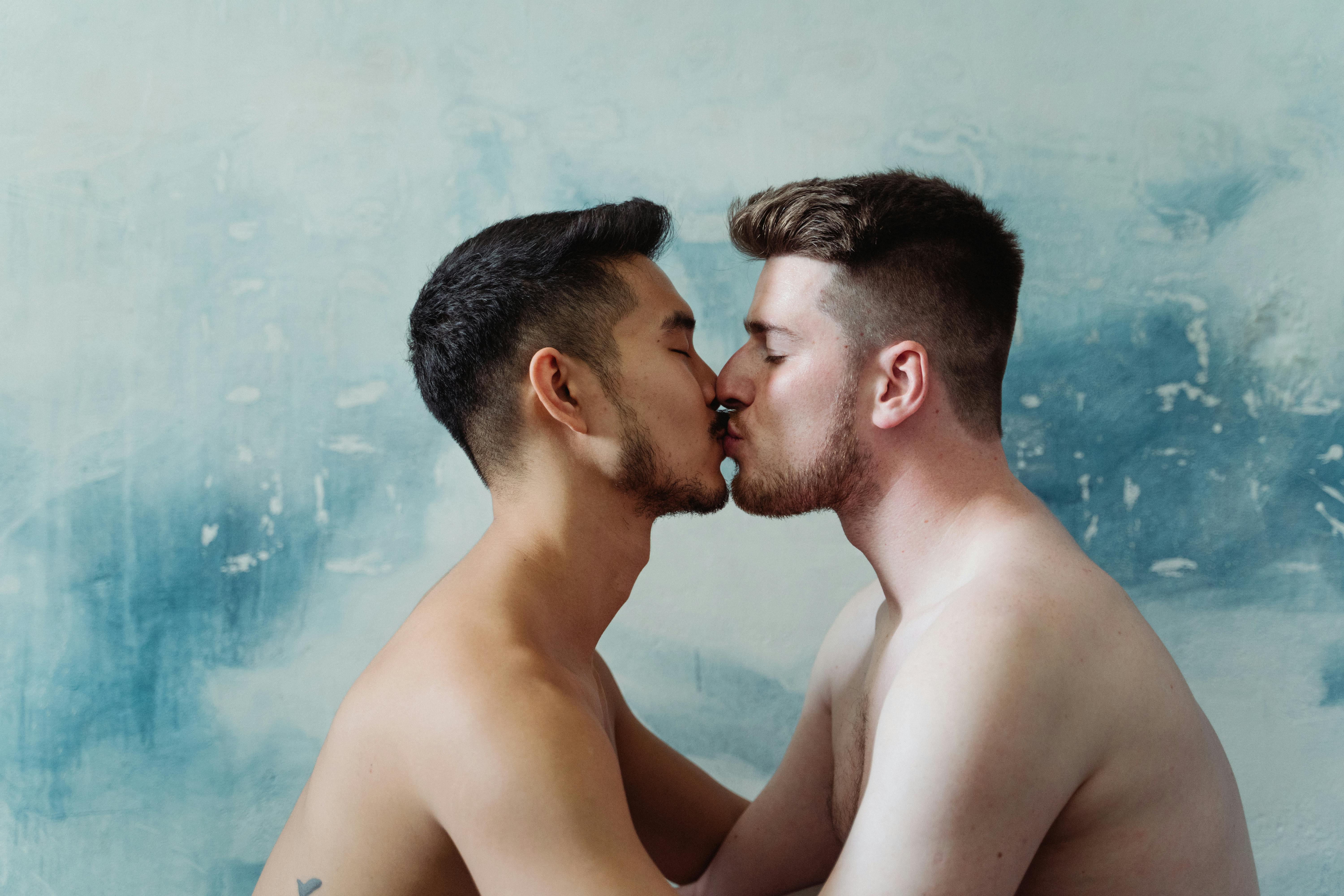 two shirtless men kissing
