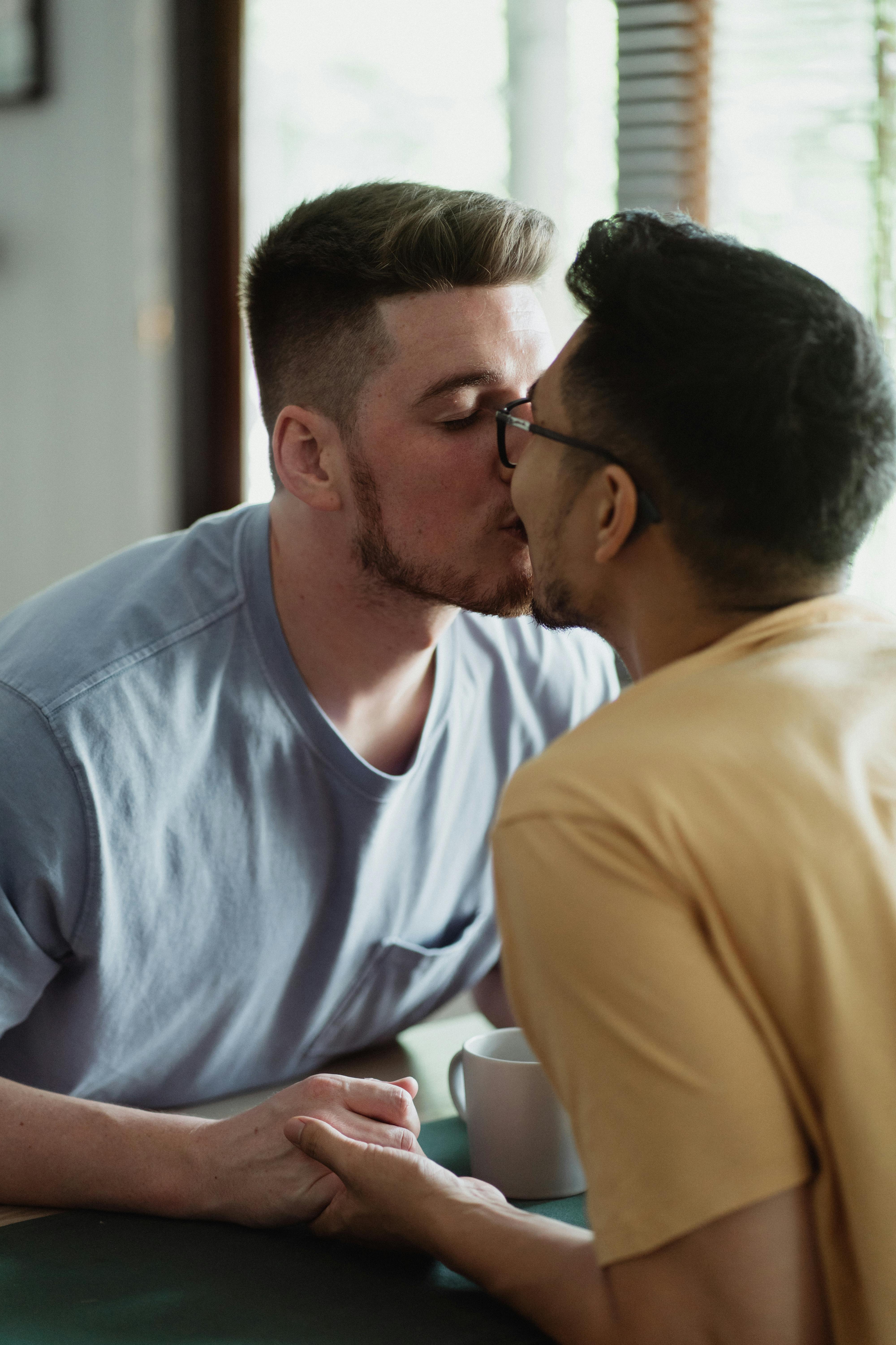 Two Men Kissing and Holding Hands · Free Stock Photo