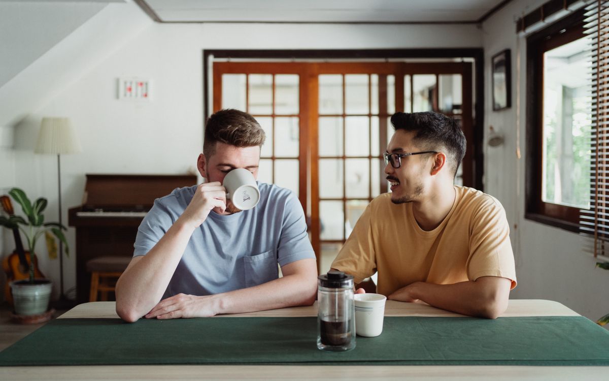 Two friends chatting over coffee at a cozy indoor setting.