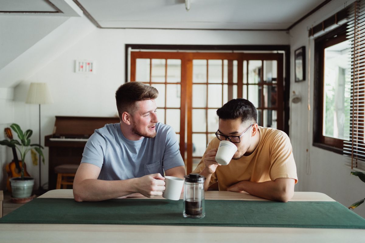 Friends sharing coffee and conversation at a table indoors