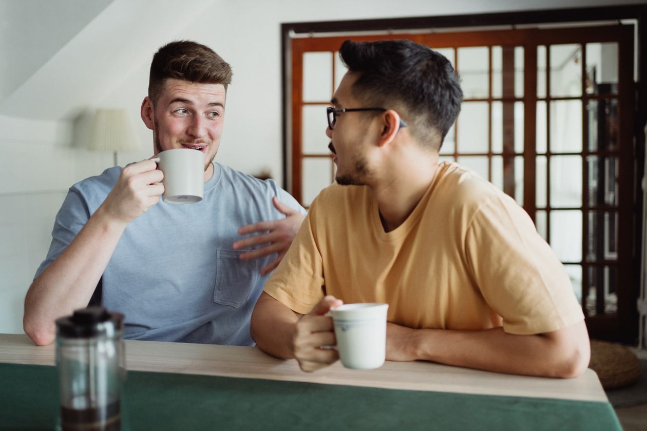 Hai người bạn trò chuyện thân mật bên tách cà phê