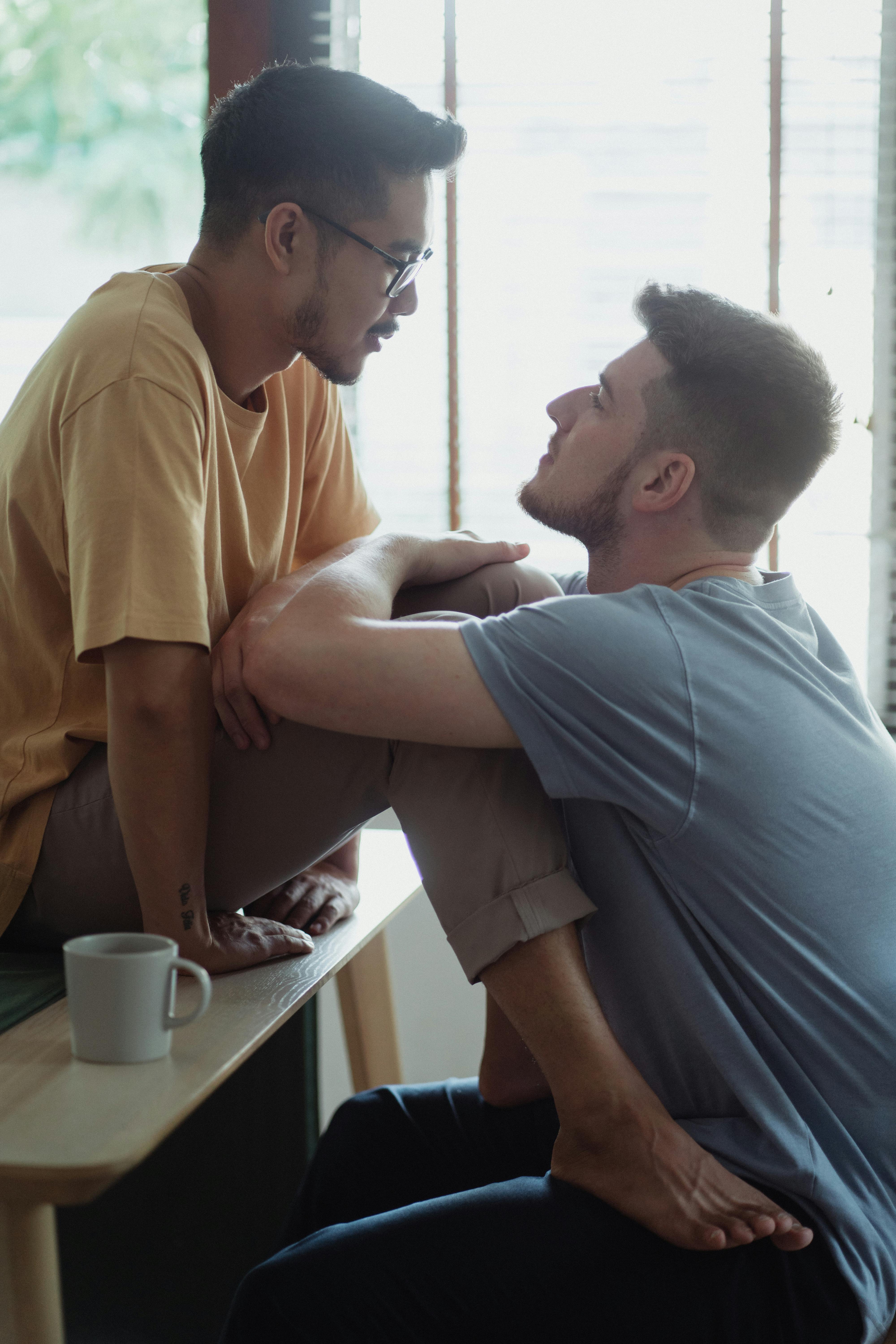 man sitting on a table with legs put on his boyfriend lap