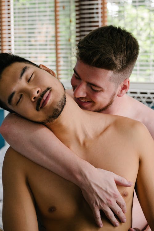 Two Shirtless Men Being Affectionate