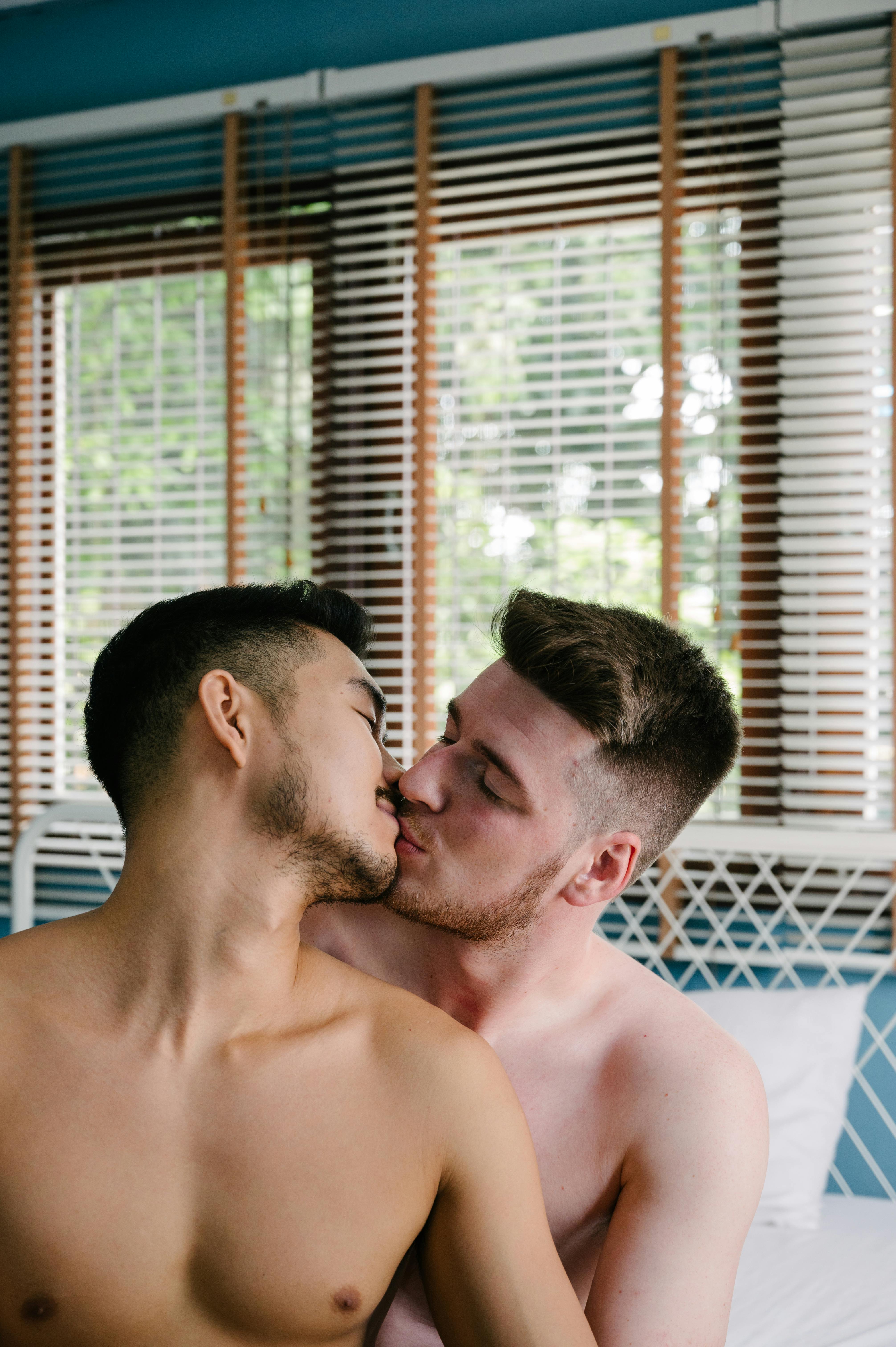 two topless men kissing