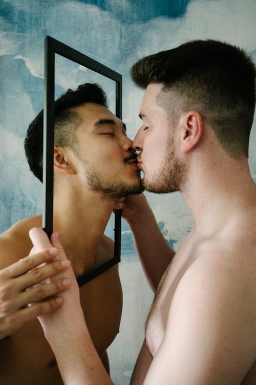 Two Men Holding a Frame and Kissing