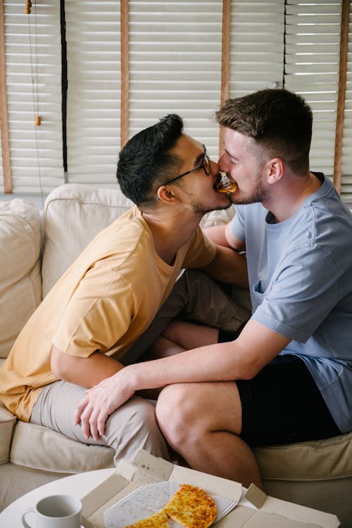 Two Men Sitting on a Couch and Being Affectionate