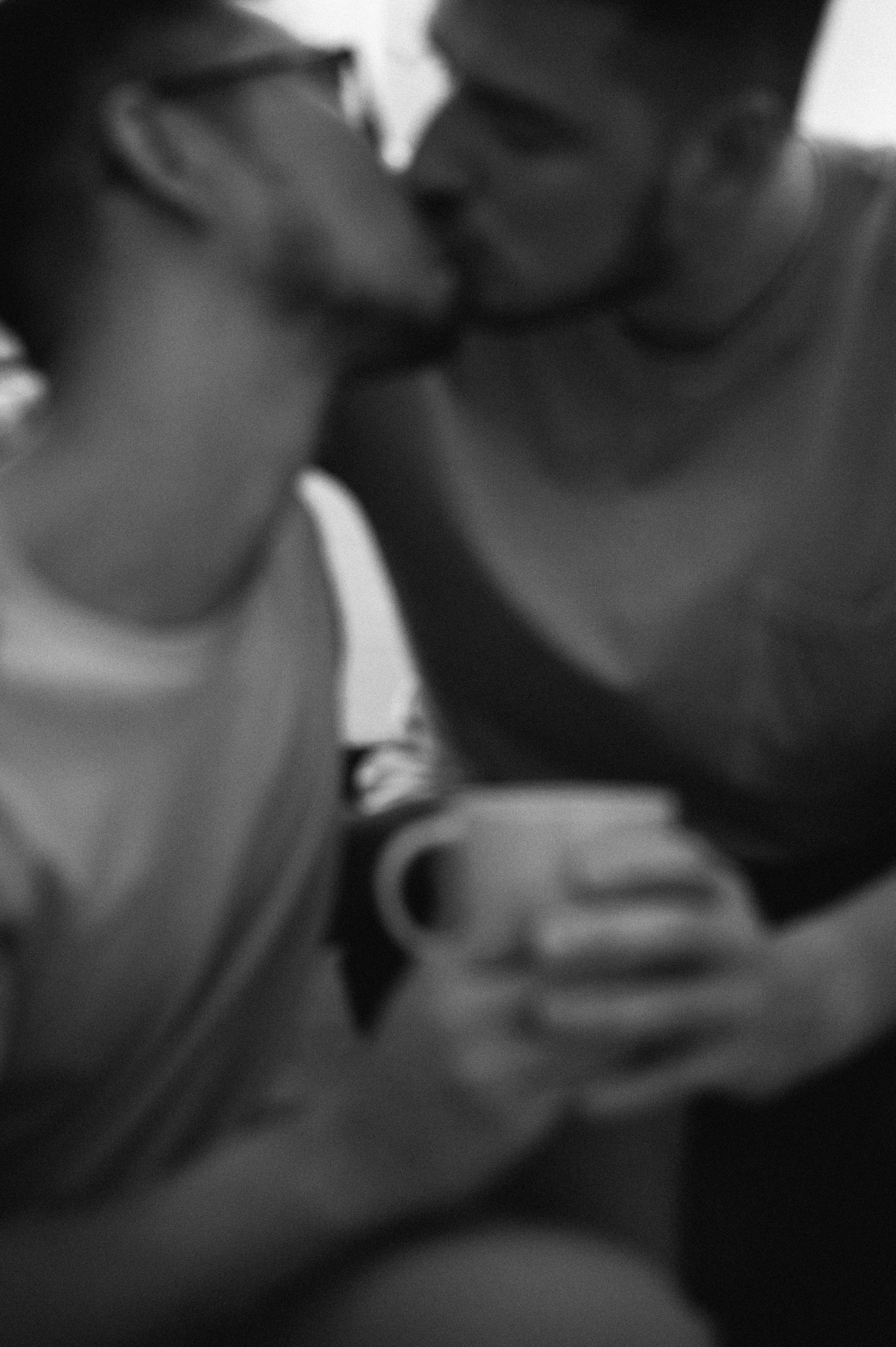 burry grayscale photo of two men kissing