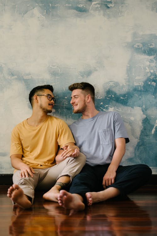 Free Two Men Sitting on the Floor and Holding Hands Stock Photo
