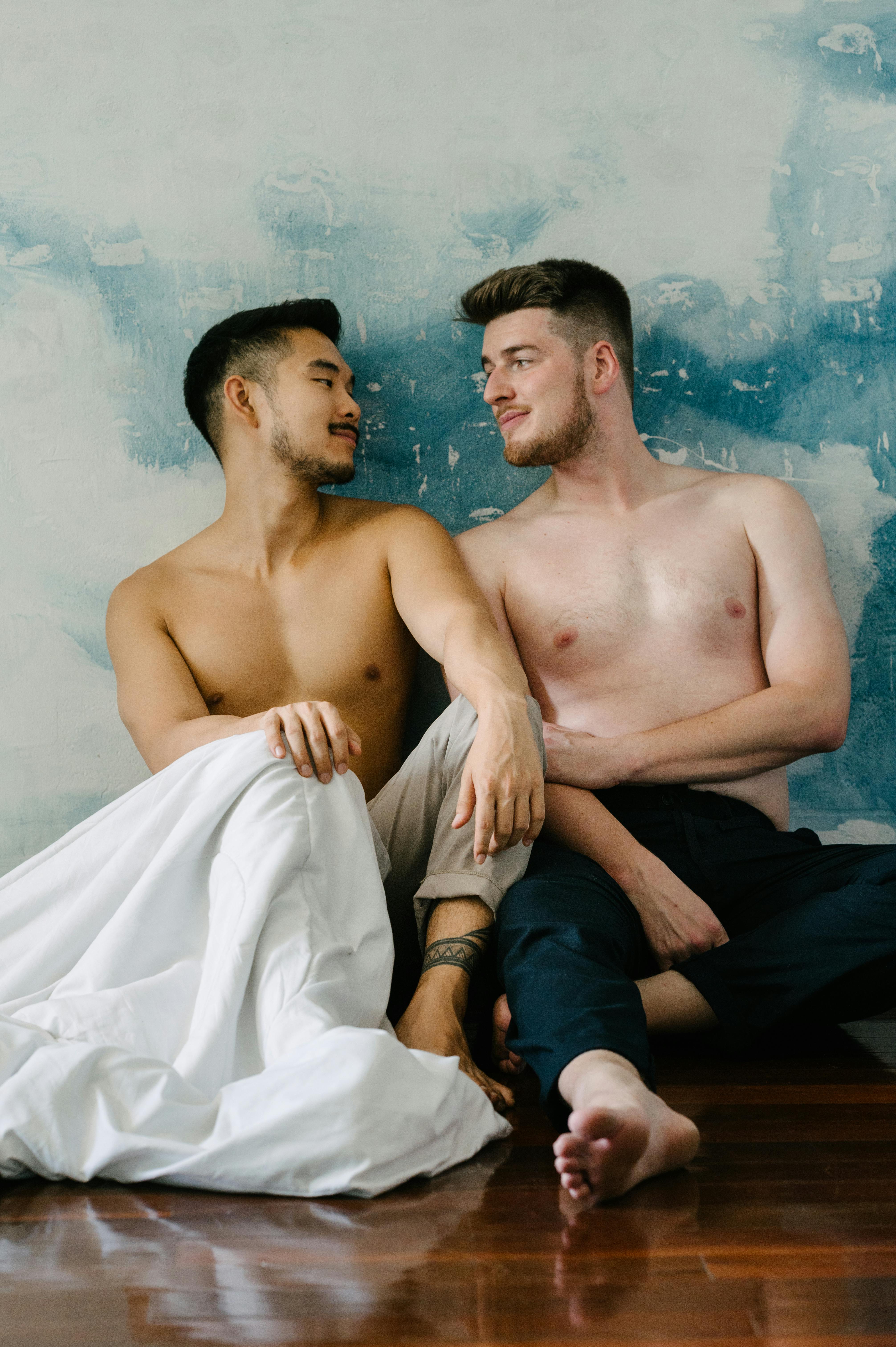 two shirtless men sitting on the floor