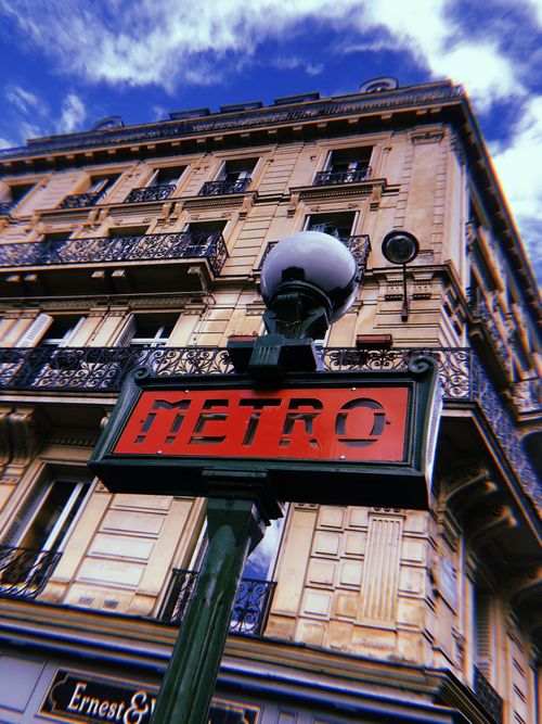 Free Parisian metro sign with classic architecture under a dramatic sky in Paris, France. Stock Photo