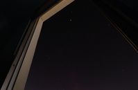 透过打开的窗户，可以看见黑暗天空中的星星