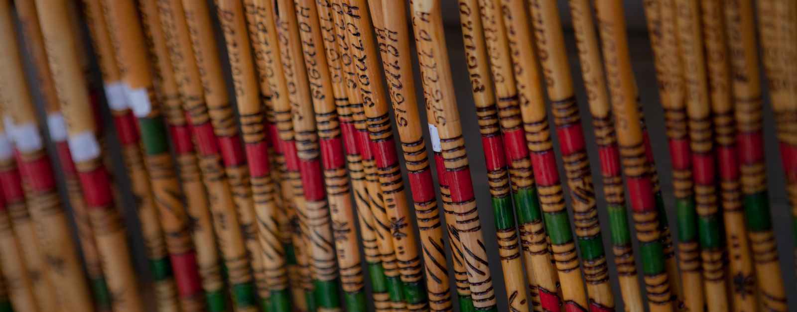 Colorful wooden canes with decorative patterns and lettering arranged in a row.
