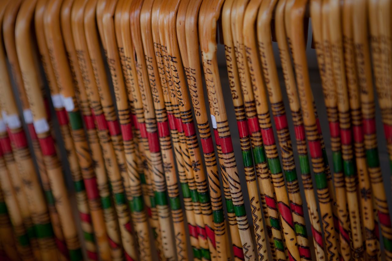 colorful wooden canes with decorative patterns and lettering arranged