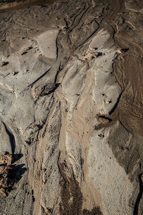Free A detailed view of an expansive dry riverbed with intricate sand textures and patterns. Stock Photo