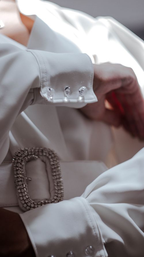 Free Crop anonymous young female in white dress with elegant transparent cufflinks and stylish belt with rhinestones on buckle Stock Photo