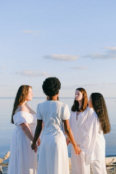 一群多元文化的女性手牵着手，在海边享受着宁静的夏夜