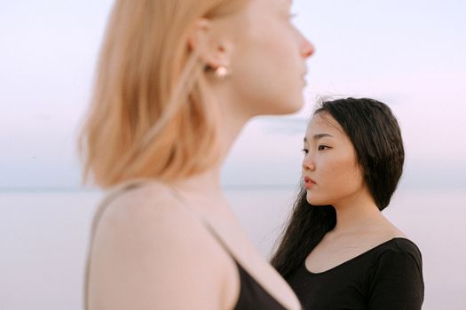 两个女人凝视着海边的地平线，心中涌起一片宁静而沉思的思绪