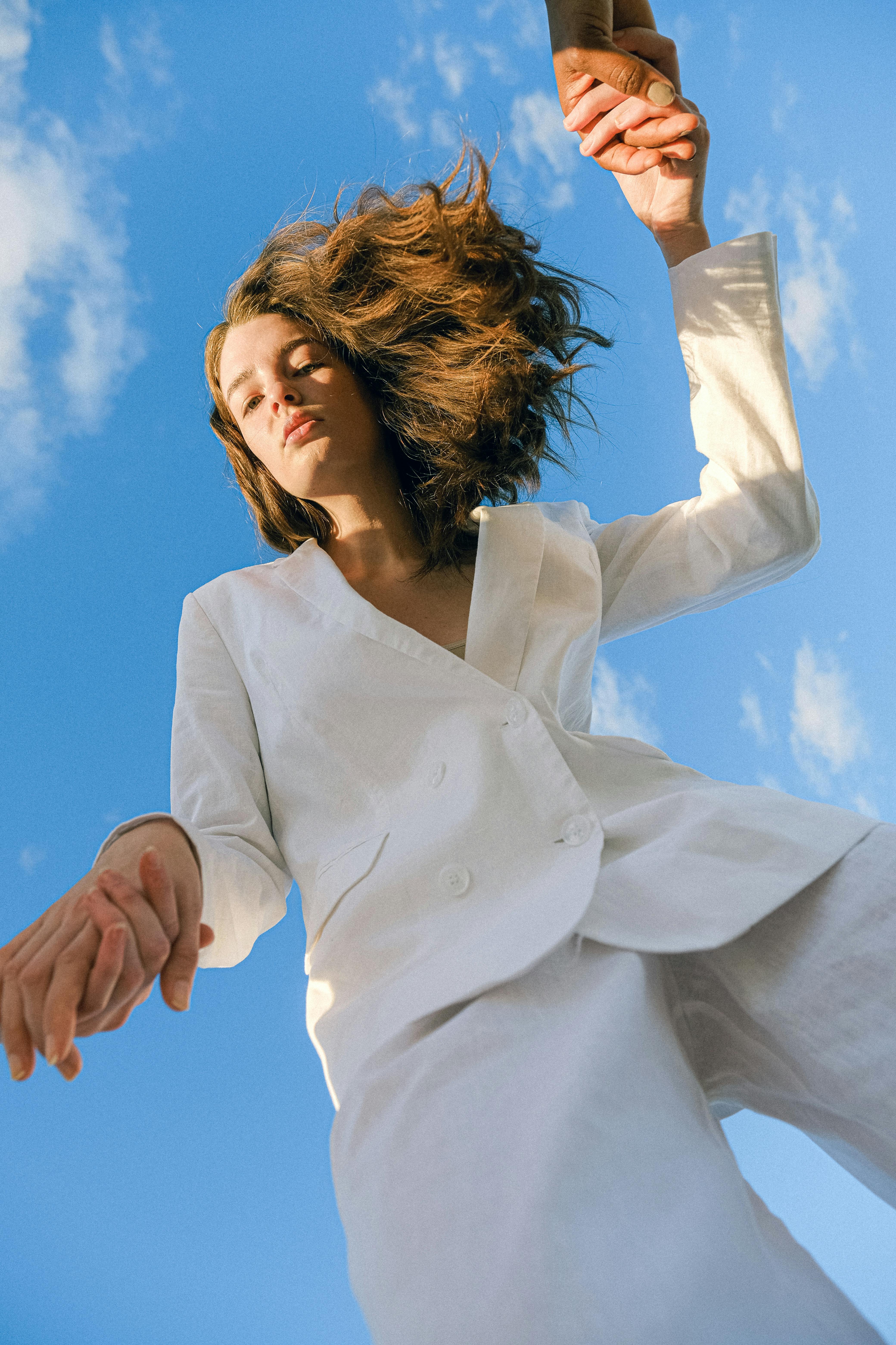 a woman in white blazer under the blue sky