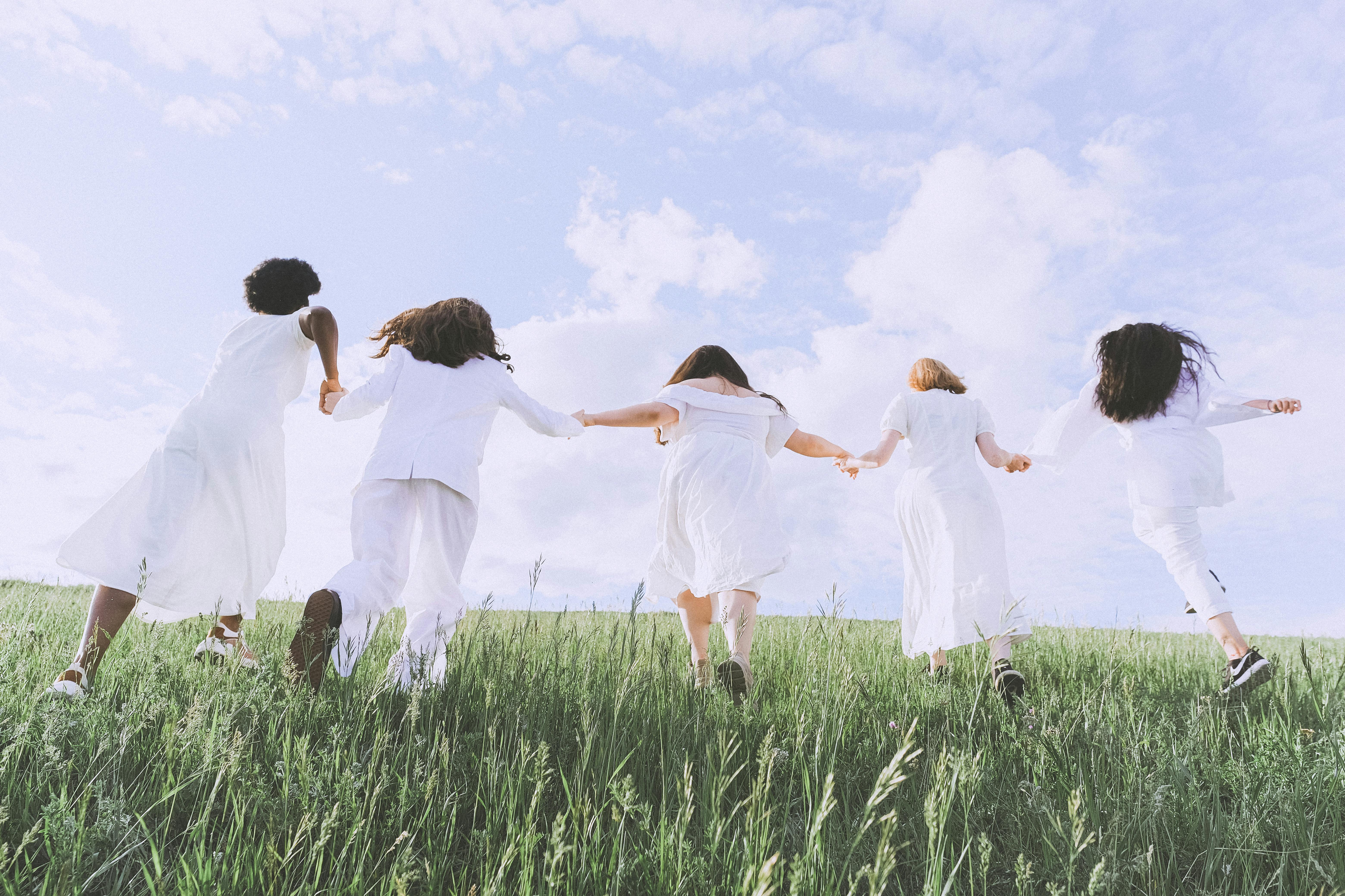 women in white dress running on green grass field