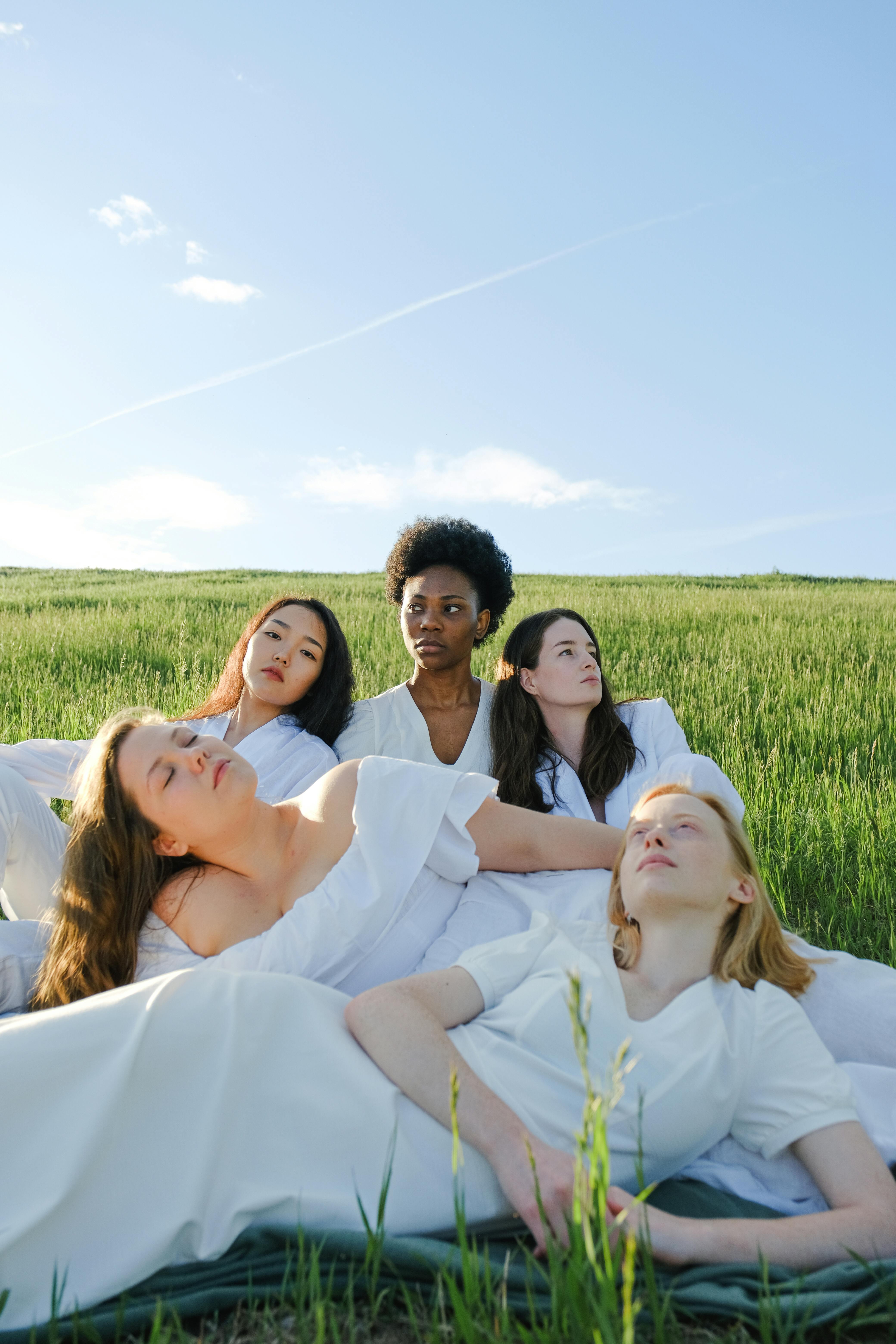 photo of women sitting on grass