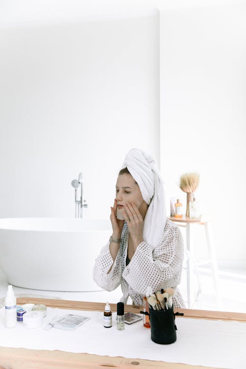 Photo Of Woman Putting Face Mask On Her Face