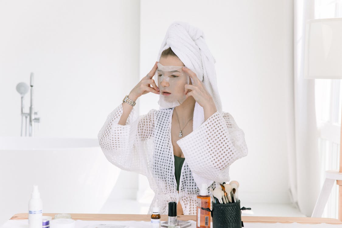 Photo Of Woman Applying Face Mask On Her Face