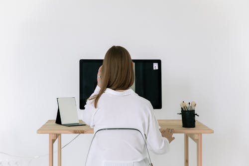 Free Woman in White Long Sleeve Shirt Sitting on a Chair Stock Photo