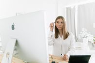 女人在电脑前化妆，将科技与自我护理融为一体
