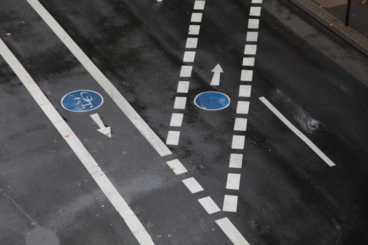 雨后，城市道路的俯视图中，自行车道标记在潮湿的表面上清晰可见