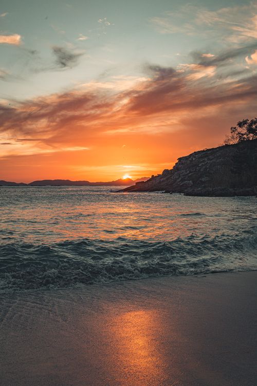Free Discover tranquility with a sunset view at a calm oceanside beach, perfect for your nature escape. Stock Photo