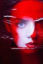 一位女性的艺术肖像，具有鲜艳的红色色调和引人注目的眼睛细节