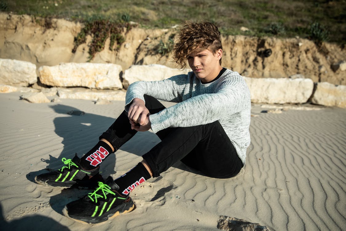 Photo Of Man Sitting On Sand · Free Stock Photo