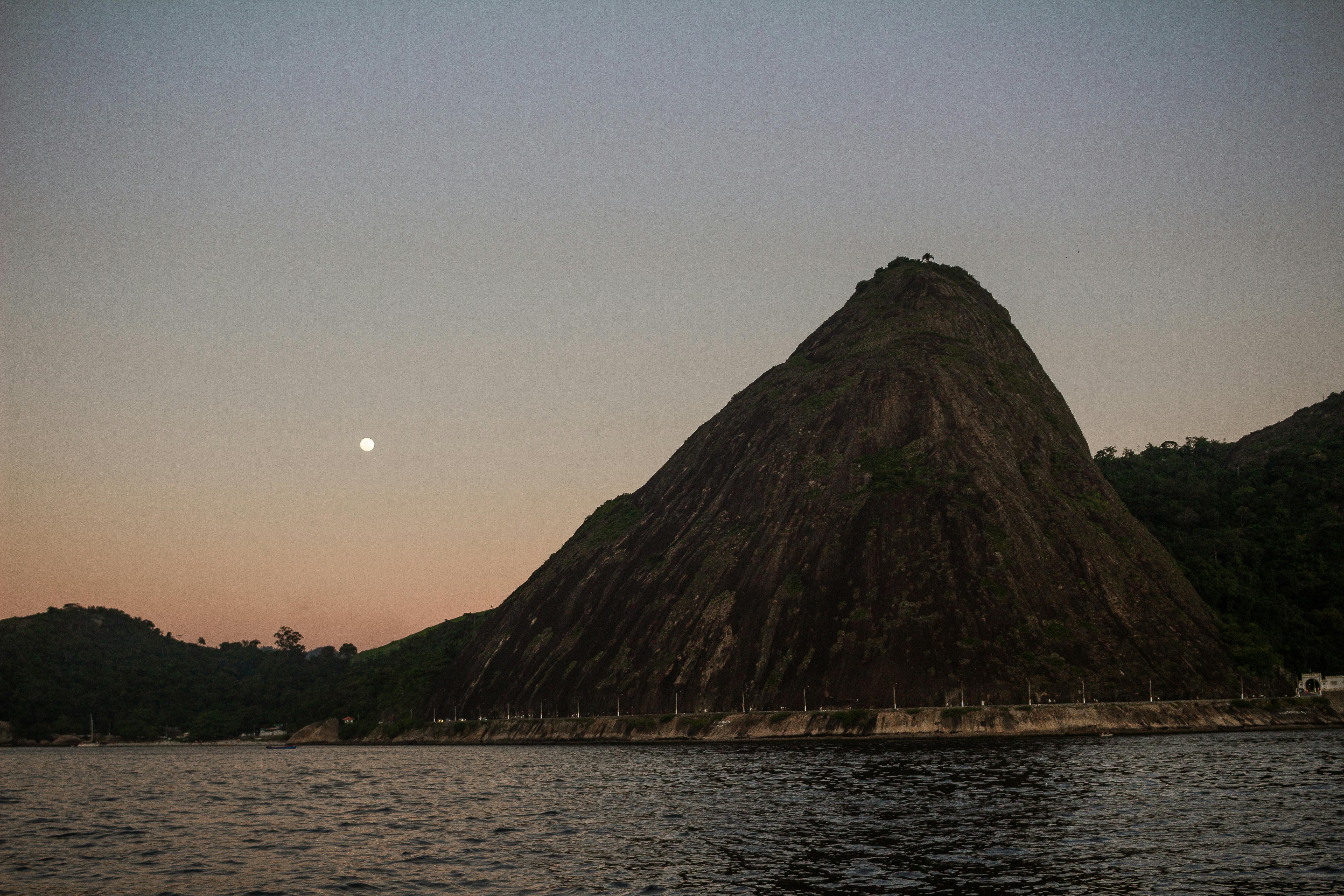 Captivating sunset over Sugarloaf Mountain in Rio de Janeiro, reflecting on the calm sea.