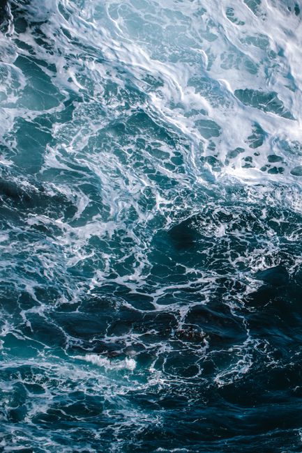 A vertical shot capturing the vibrant blue waves of the Pacific Ocean near California.