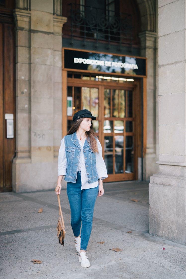 A Woman In Blue Denim Jacket Walking On The Street