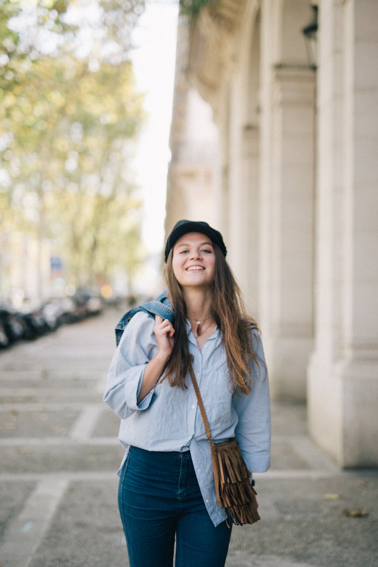 Smiling Woman Carrying Her Denim Jacket On Her Shoulder 