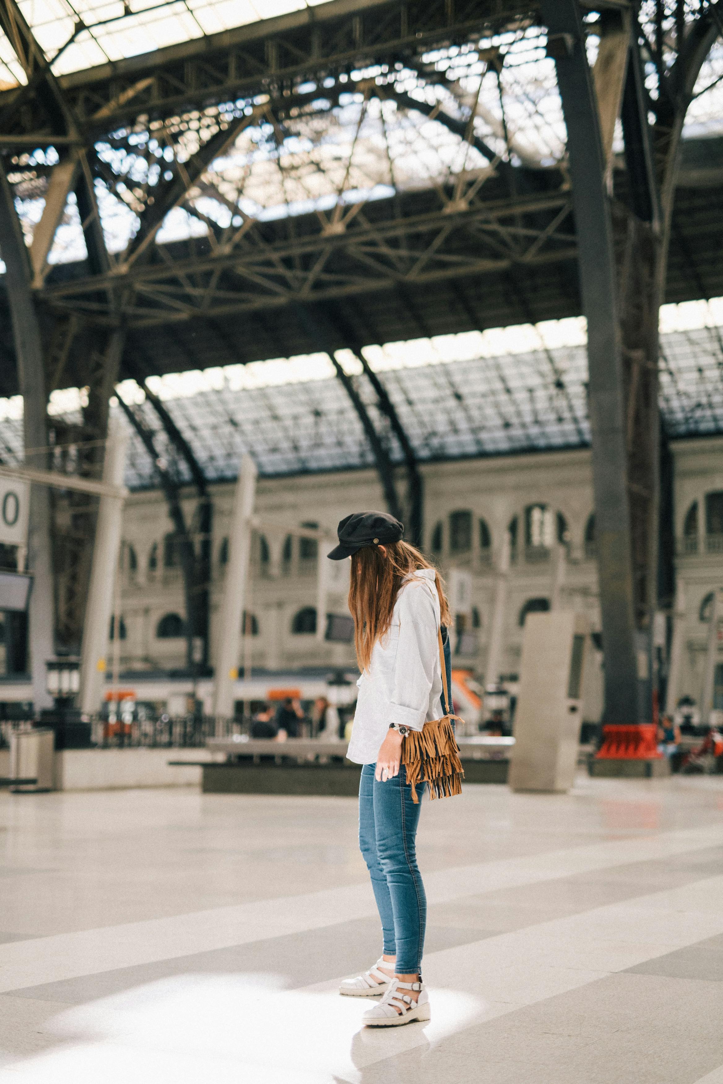 woman in white long sleeve shirt and blue denim jeans standing on the platform