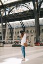 年轻女子在现代火车站的城市环境中等候，展现了旅行和通勤的主题