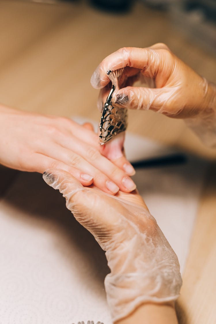 A Manicurist Wearing Gloves Servicig A Client