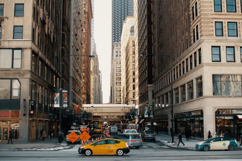 Free Cars driving on asphalt road between contemporary skyscrapers and buildings in New York City in daytime Stock Photo