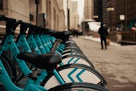 Row of modern similar bicycles parked on street near contemporary building in city on winter day