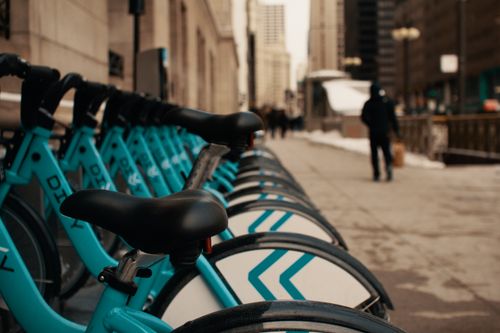 Free Row of modern similar bicycles parked on street near contemporary building in city on winter day Stock Photo