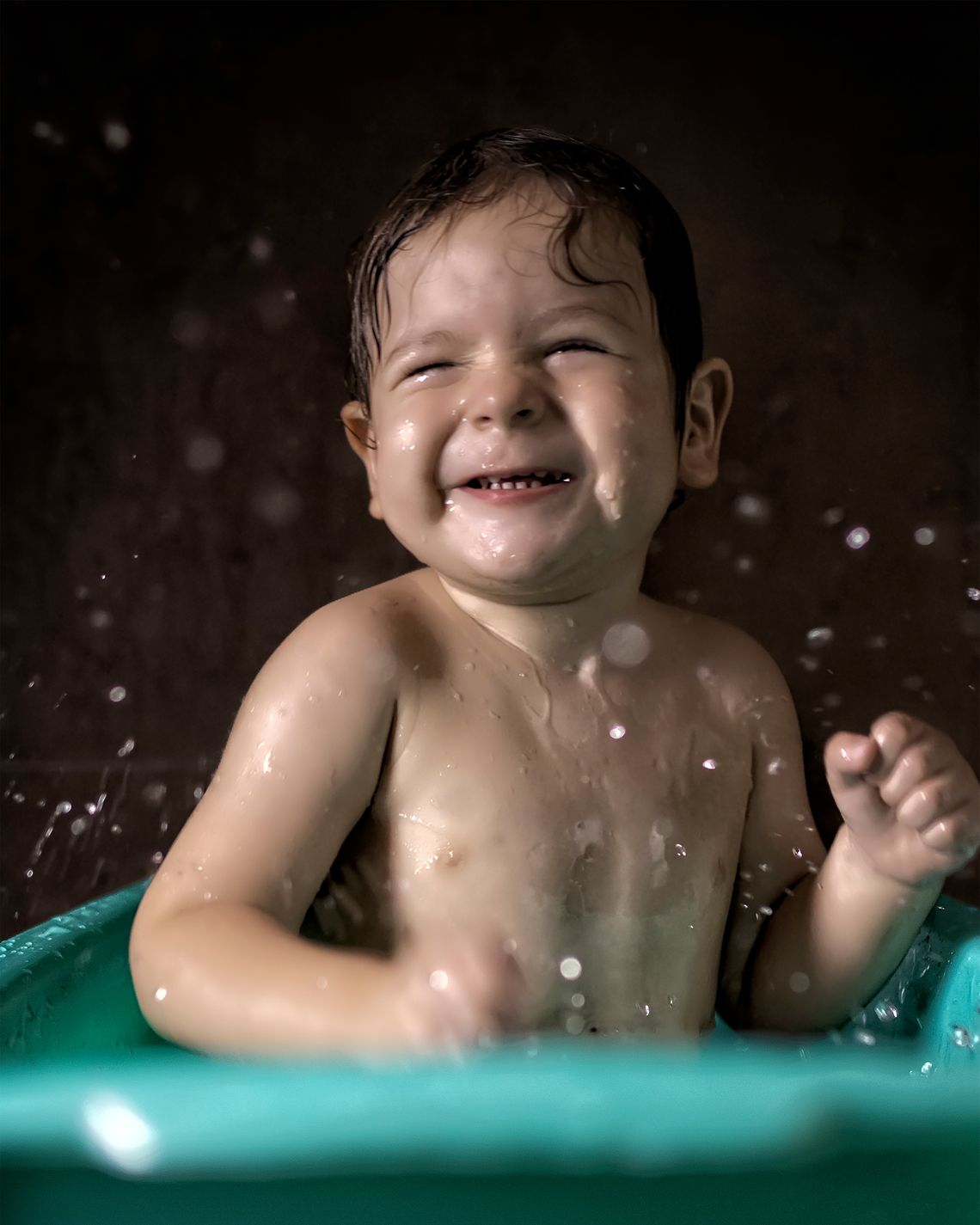 Baby enjoying a gentle bath in a small tub