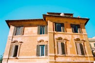 在充满活力的蓝天下，古老的建筑有着详细的浅浮雕和木制百叶窗