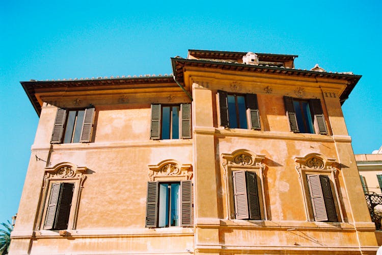 Old Residential Building With Bas Reliefs And Wooden Shutters